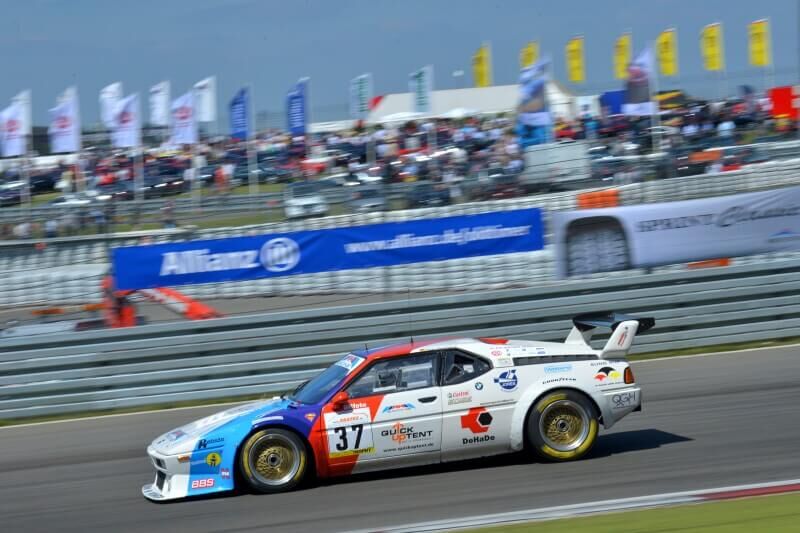 BMW M1 Seitenansicht mit dem Logo der QUICKUPTENT GmbH, DEM Faltzelt-Anbieter